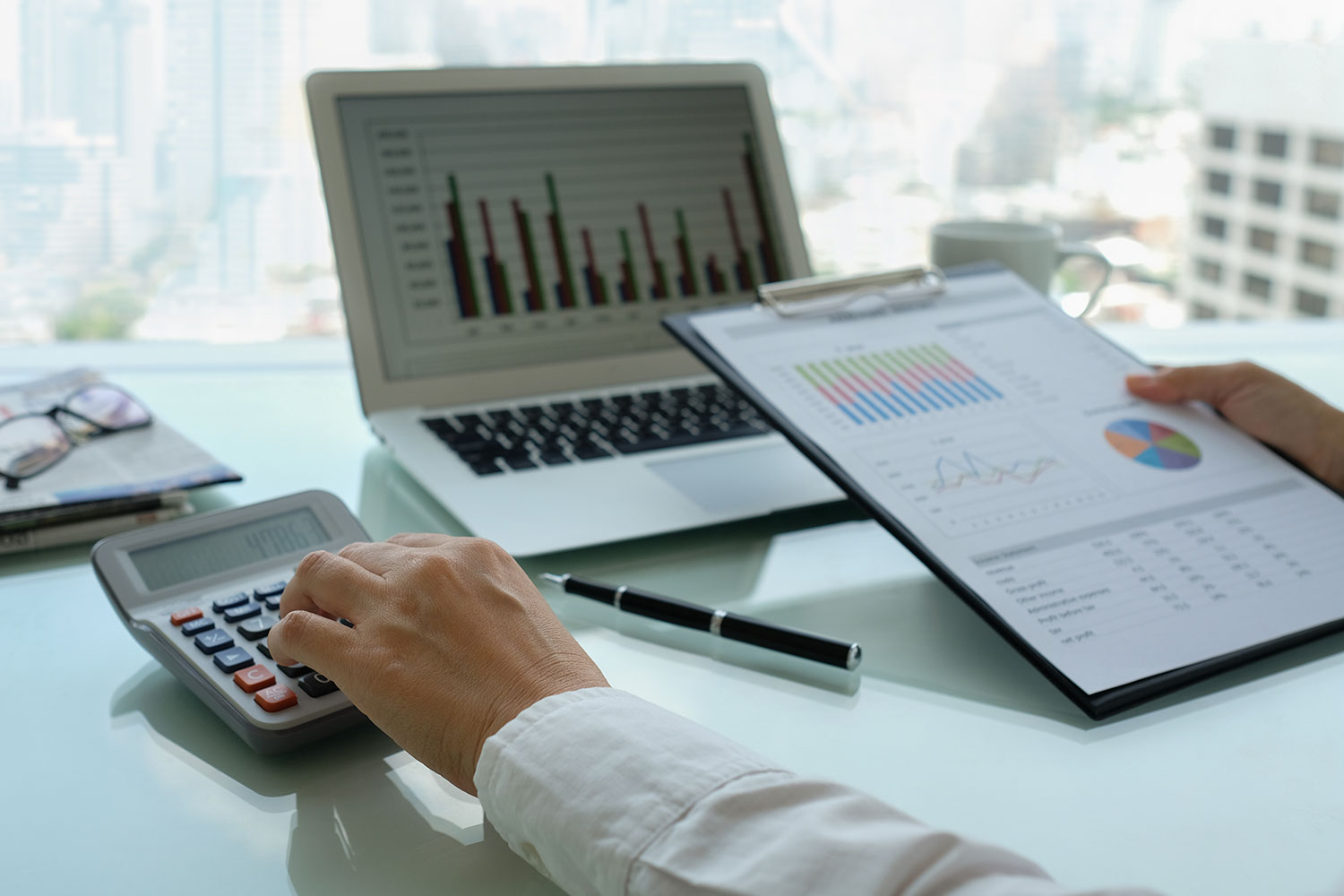 man working with laptop and clipboard, deciphering finances